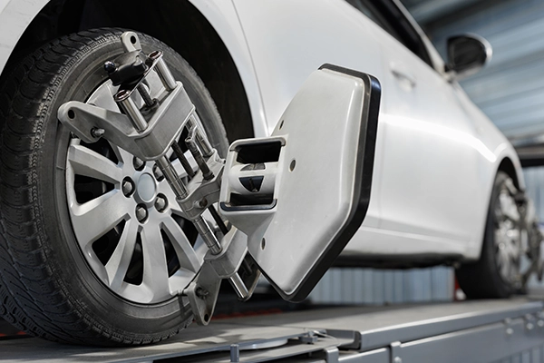 White vehicle sitting on alignment rack