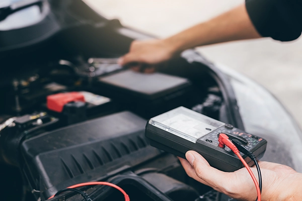 Technician testing battery charge with multimeter