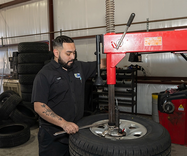 Technician installing tire on wheel