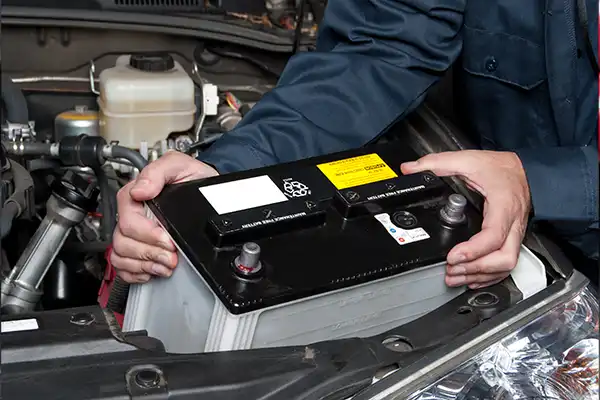 tech holding a car battery